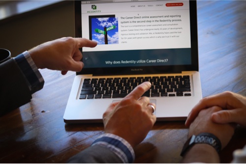man pointing to laptop screen